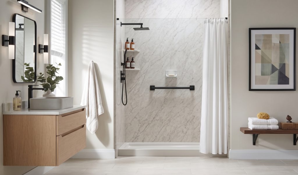 A bright walk-in shower with marble-look walls, a black shower head, and a grab bar